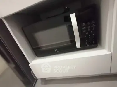 Modern kitchen with built-in microwave oven in sleek cabinetry.