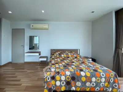 Spacious bedroom with modern decor and large window for natural light