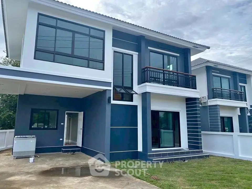 Modern two-story house with sleek design and large windows, featuring a spacious driveway and lush green lawn.
