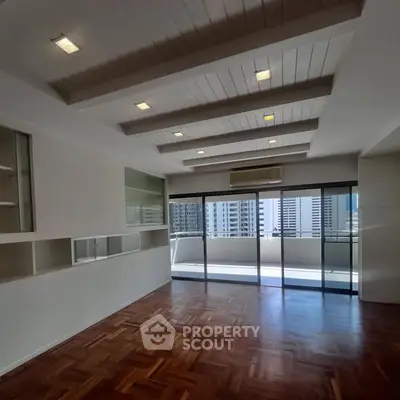 Spacious living room with parquet flooring and large balcony in urban apartment