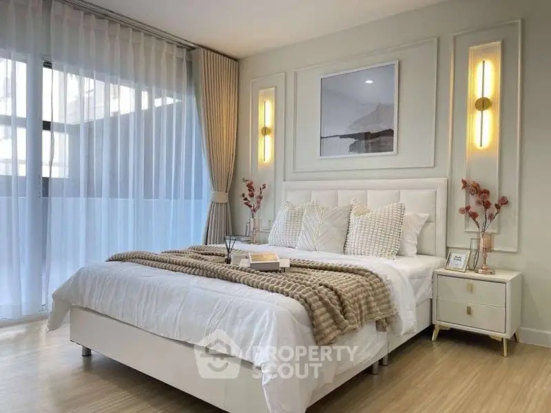 Elegant bedroom with modern decor and large window for natural light.