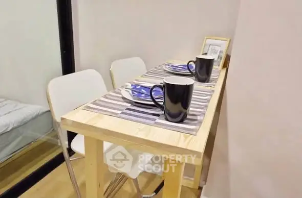 Cozy dining nook with wooden table and modern chairs in compact apartment setting.