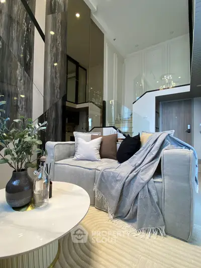 Luxurious modern living room with elegant decor and high ceilings, featuring a cozy sofa and stylish coffee table.