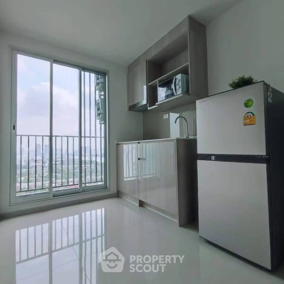 Modern kitchen with sleek cabinets and city view from large window.