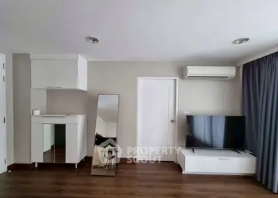 Modern living room with sleek TV setup and stylish mirror accent