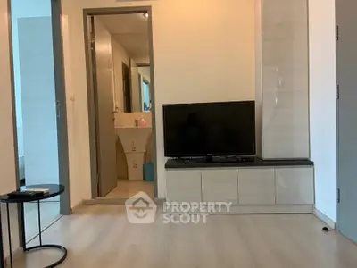 Modern living room with sleek TV stand and open bathroom view, showcasing minimalist design.
