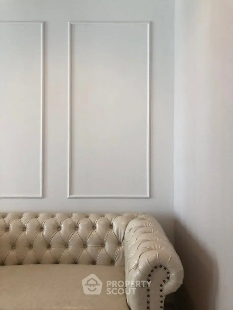 Elegant living room with classic tufted sofa and minimalist wall design