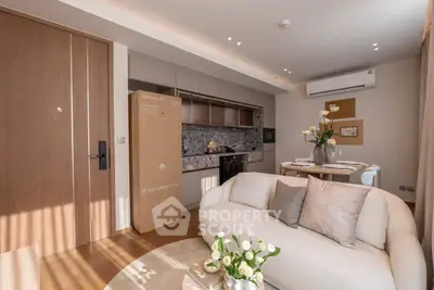 Modern living room with cozy sofa, stylish kitchen, and elegant dining area in open layout apartment.