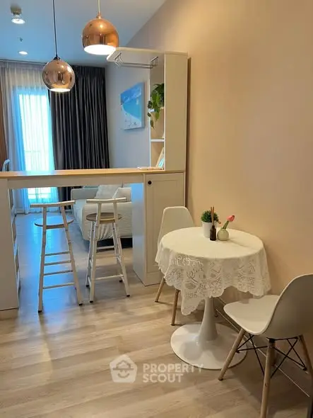 Modern living room with stylish decor and cozy dining area, featuring elegant lighting and contemporary furniture.