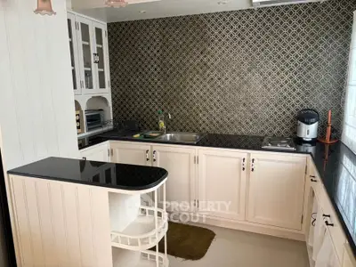 Charming kitchen with elegant cabinetry and modern appliances, featuring a stylish backsplash and sleek countertops.