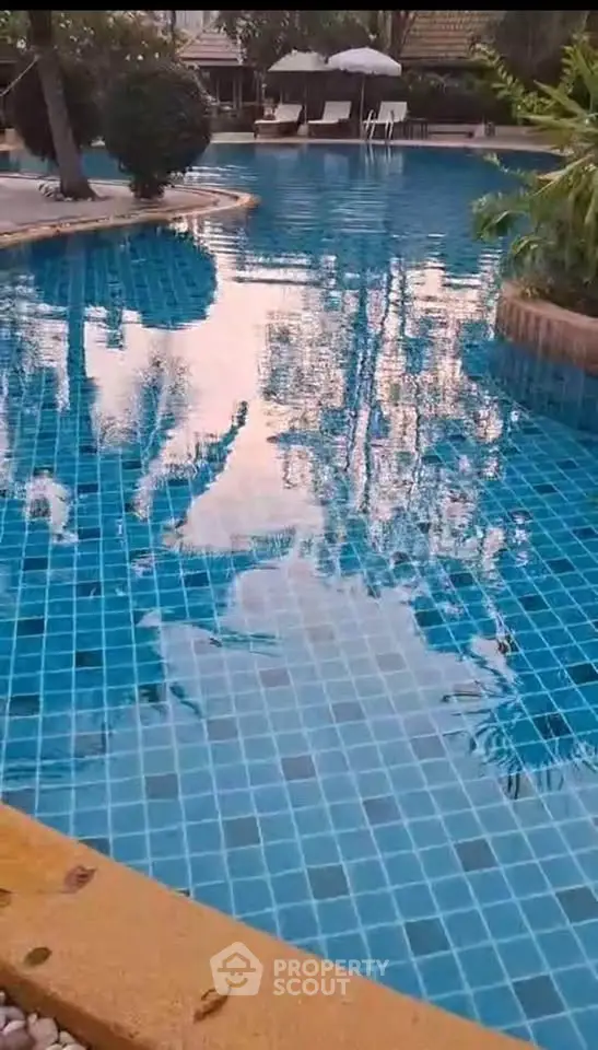 Luxurious swimming pool with serene surroundings and elegant poolside seating.