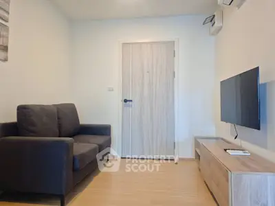 Modern living room with sleek furniture and wall-mounted TV in a cozy apartment.