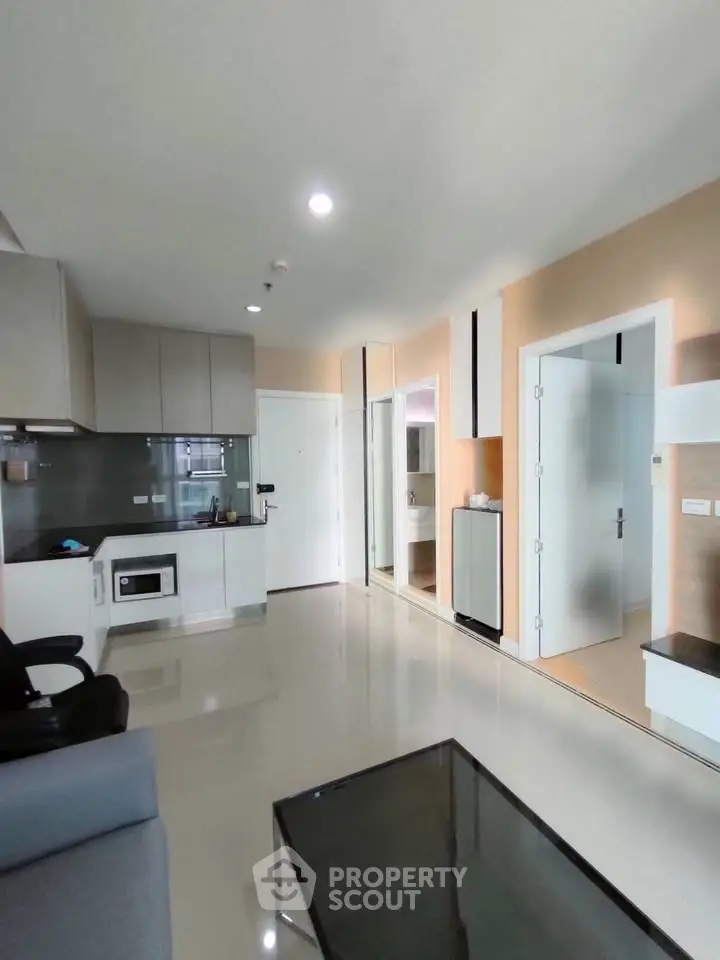 Modern open-plan living room with sleek kitchen and glossy floors in a stylish apartment.