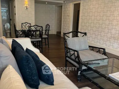 Elegant living room with stylish furniture and dining area, featuring modern decor and hardwood floors.