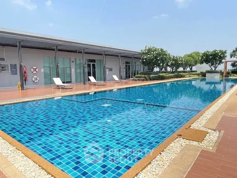 Luxurious outdoor swimming pool with sun loungers and modern design, perfect for relaxation and leisure.