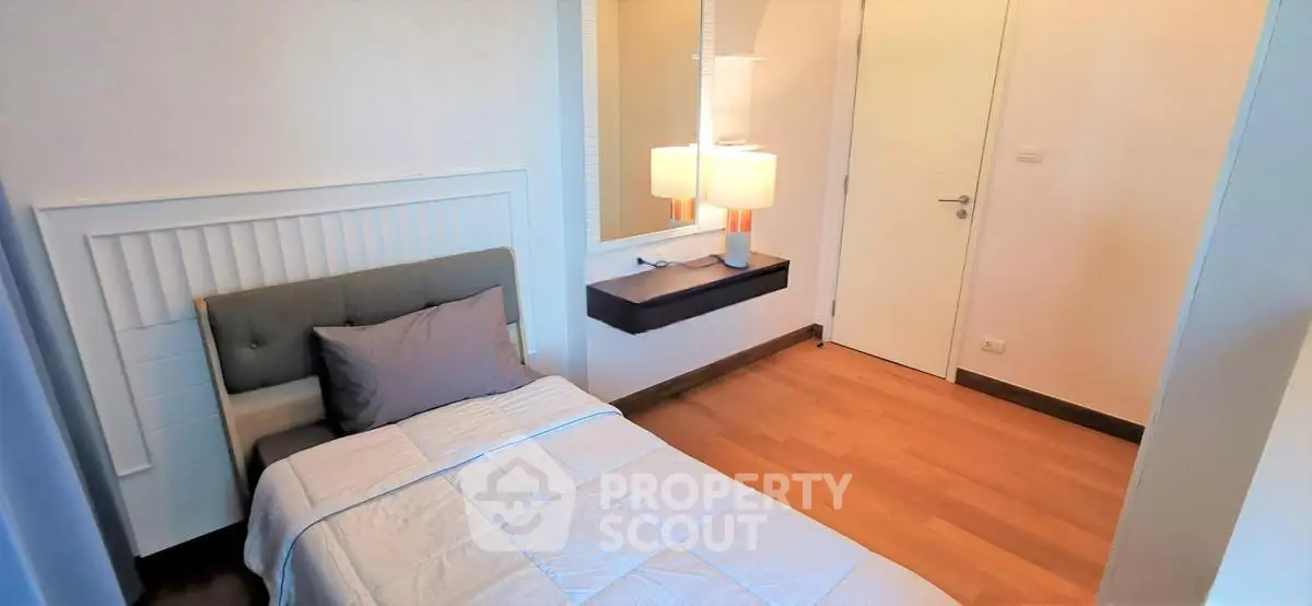 Cozy bedroom with modern decor and wooden flooring in a stylish apartment.