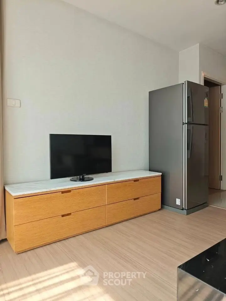 Modern living room with sleek TV stand and stainless steel refrigerator