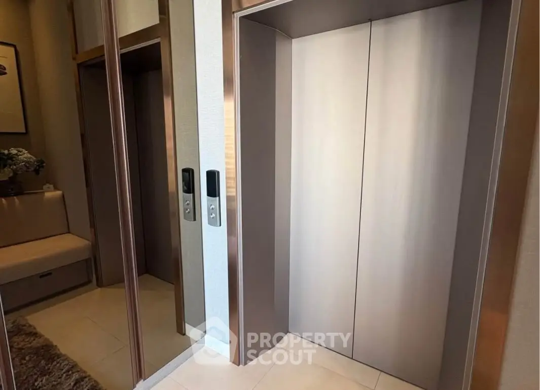 Modern elevator in upscale residential building with sleek design and mirrored walls.