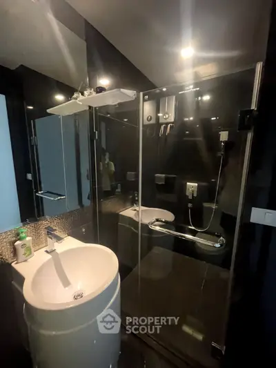 Modern bathroom with sleek glass shower and stylish sink in contemporary design.