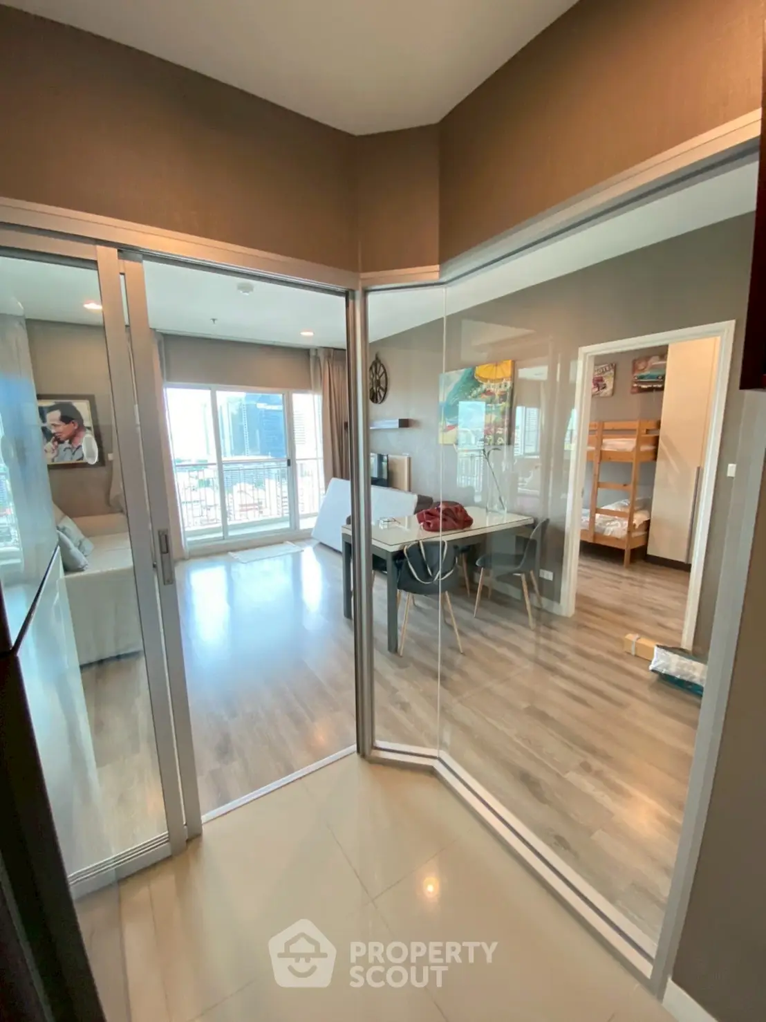Modern condo interior with glass doors and wooden flooring