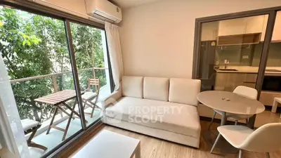 Modern living room with balcony view and open kitchen layout in stylish apartment.