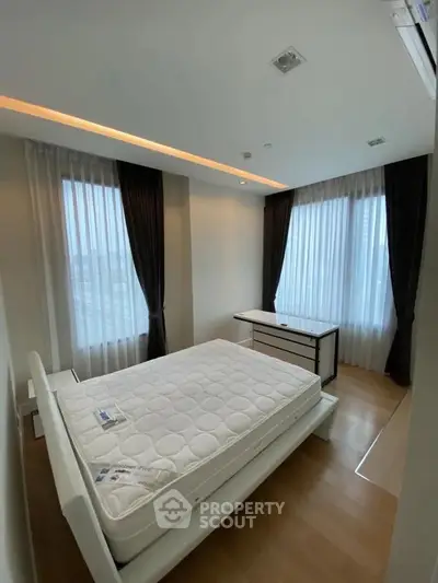Modern bedroom with sleek design and large windows for natural light.