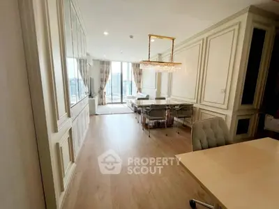 Luxurious open-plan living and dining area with elegant decor and city view.