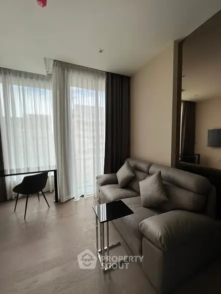 Modern living room with stylish sofa and large windows offering natural light.