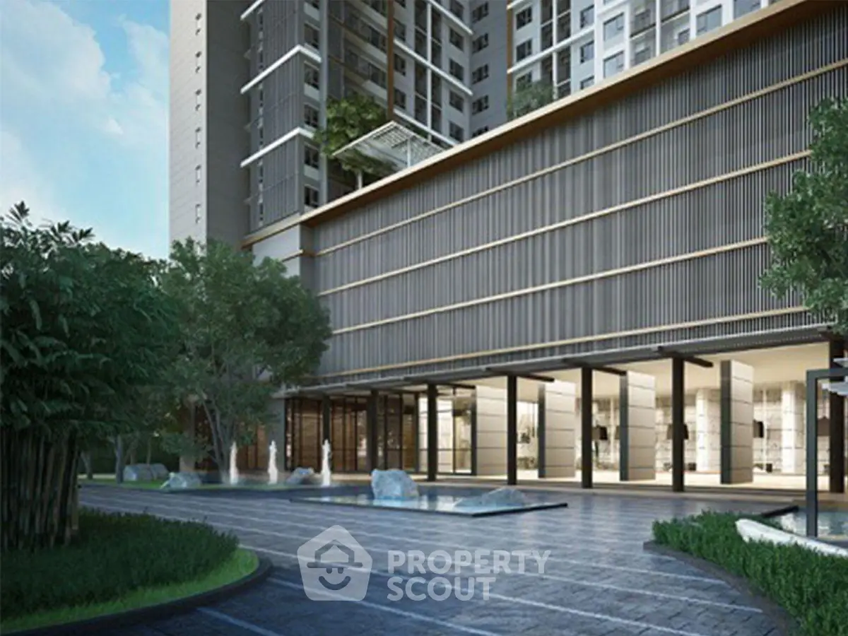 Modern apartment building entrance with sleek design and lush greenery.
