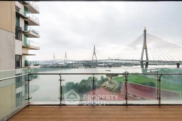 Stunning balcony view of modern bridge and river from high-rise apartment.