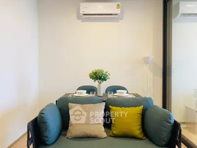 Modern living room with stylish sofa and dining area, featuring air conditioning and elegant decor.