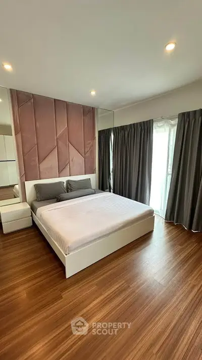 Spacious modern bedroom with elegant wood flooring and stylish decor