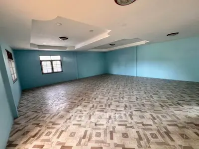 Spacious empty room with tiled flooring and blue walls, ideal for customization.