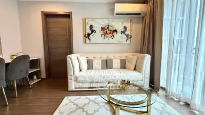 Elegant living room with plush sofa, stylish decor, and natural light from large windows.