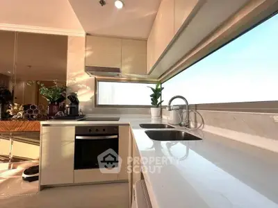 Modern kitchen with sleek design, large window, and built-in oven