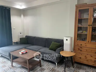 Cozy living room with modern gray sofa and wooden furniture, perfect for relaxation.