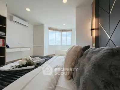 Luxurious bedroom with modern decor and large windows offering stunning views.