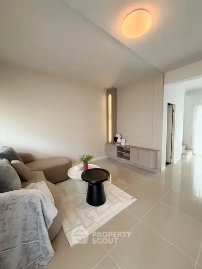 Modern living room with sleek furniture and elegant decor, featuring a cozy sofa and stylish coffee table.