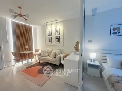 Modern living room with stylish decor and adjacent bedroom in open-plan apartment.
