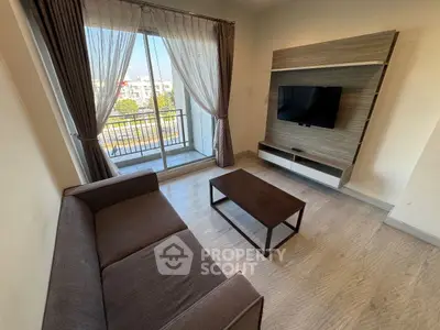 Modern living room with balcony view, sleek furniture, and natural light.