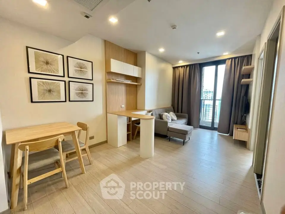 Modern living room with stylish decor and balcony view in a contemporary apartment.
