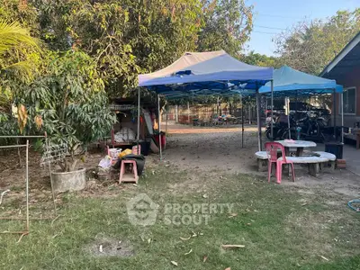 Spacious outdoor area with tents and seating, ideal for gatherings or events.