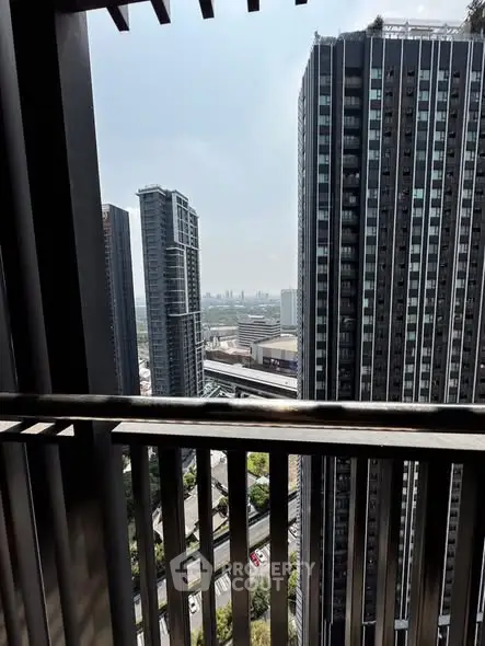 Stunning urban view from high-rise balcony overlooking city skyline and modern architecture.