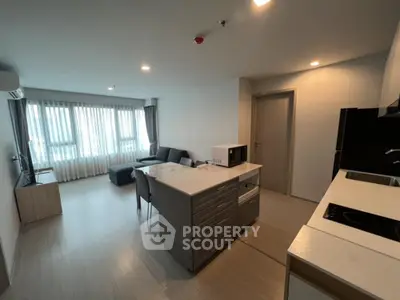 Modern open-plan living room and kitchen with sleek design and ample natural light.