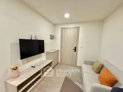 Cozy modern living room with sleek furniture and wall-mounted TV, perfect for relaxation.