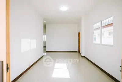 Spacious empty room with large window and glossy tiled floor