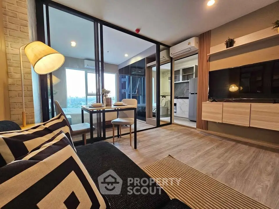 Modern living room with stylish decor and open layout, featuring a cozy dining area and large windows.