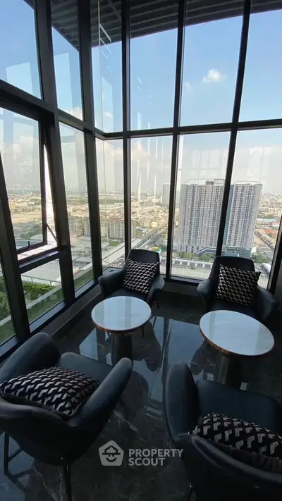 Luxurious high-rise apartment with stunning city view and elegant seating area.