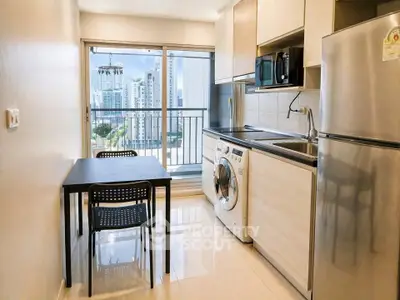 Modern kitchen with balcony view, featuring sleek appliances and dining area in a high-rise apartment.