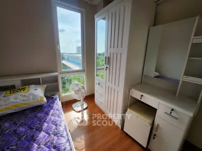 Cozy bedroom with natural light and modern furnishings, featuring a scenic window view.